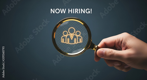 Hand holding magnifying glass over now hiring icon on dark background