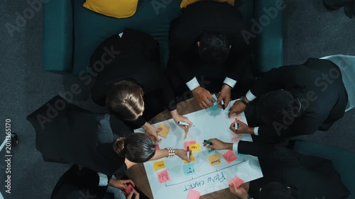 Top down view of business people hands making scrum task board to manage workflow in workplace. Diverse marketing team drawing a line and use colorful stick notes to work on kanban. Directorate.