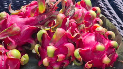 Close up of fresh organic dragon fruit pitaya with vibrant scales in a local market basket for healthy exotic lifestyle and tropical nutrition concept