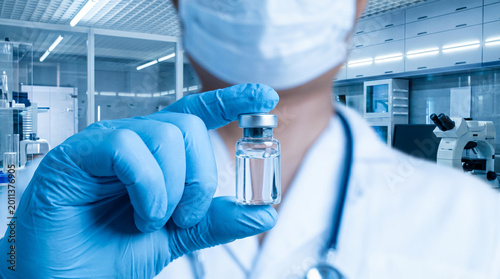 Doctor with stethoscope displaying medicine vial, healthcare and laboratory concept.