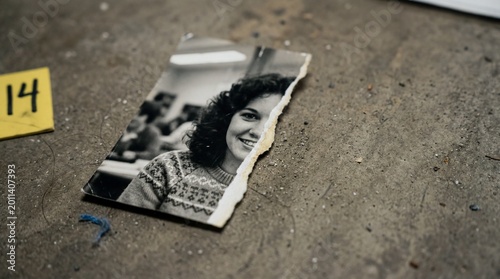 Torn old black and white photograph clue at crime scene
