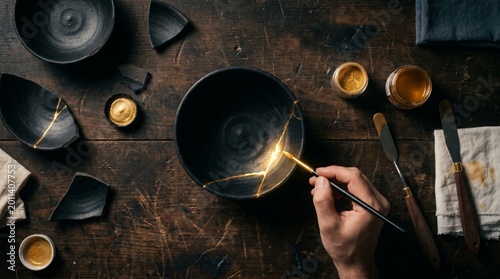 Golden Kintsugi Repair Process on Dark Ceramic Bowl