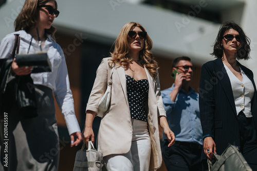 Fotografi Businesspeople walking confidently down a city street dressed in professional attire