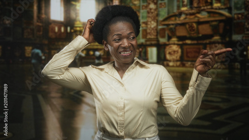 Canvastavla Woman pointing finger and scratching head in ornate cathedral building interior, grimacing with index finger extended toward a distant detail; awkward confusion