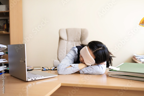 Fényképezés Business woman in a mask blindfolded asleep in the office
