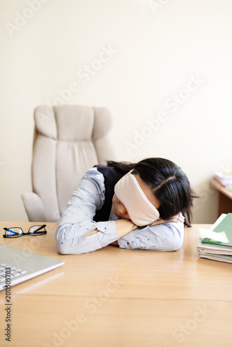 Obraz na plátně Business woman in a mask blindfolded asleep in the office