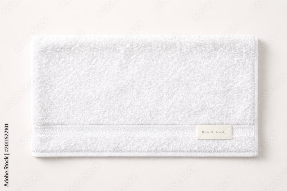 Fototapeta premium Plain background featuring a horizontal layout of a white terry towel with brand label for design use