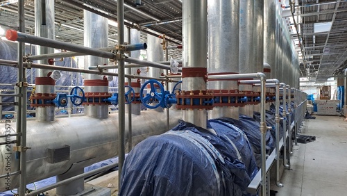 industrial piping system with blue valves and steel pipes in a data center under construction