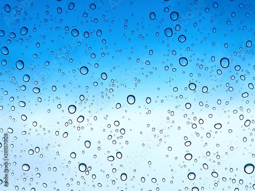 Fotografie Water droplets on blue gradient glass background after rain
