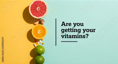 Top view of citrus fruits and vitamin pills on a yellow and blue background