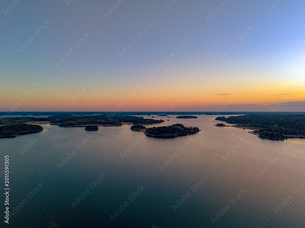 Obraz premium Top-down aerial view of small boats at a wooden pier on the rocky coast of Turku Archipelago