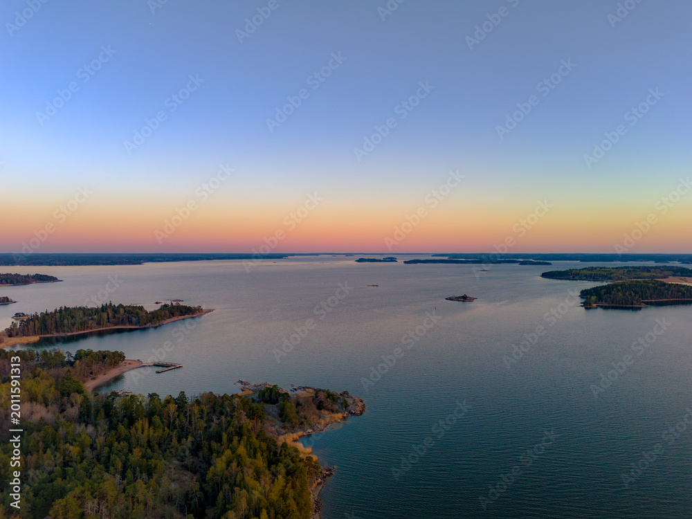Fototapeta premium Top-down aerial view of small boats at a wooden pier on the rocky coast of Turku Archipelago