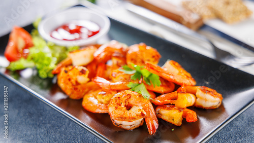 Fotografie gourmet grilled prawns with ketchup and side salad on black plate
