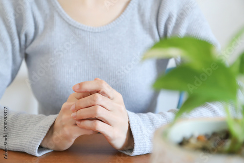 Canvastavla 手を組んで考える女性の手元