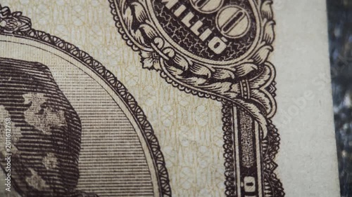 The edge design detail of an antique Hungarian 100 million pengo banknote from 1946. The footage highlights ornate border engraving, denomination ornament, and fine linework.