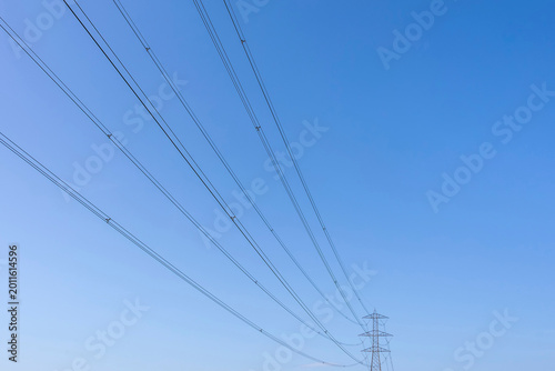 Tablou pe pânză A high voltage pylon with long cables against the blue sky