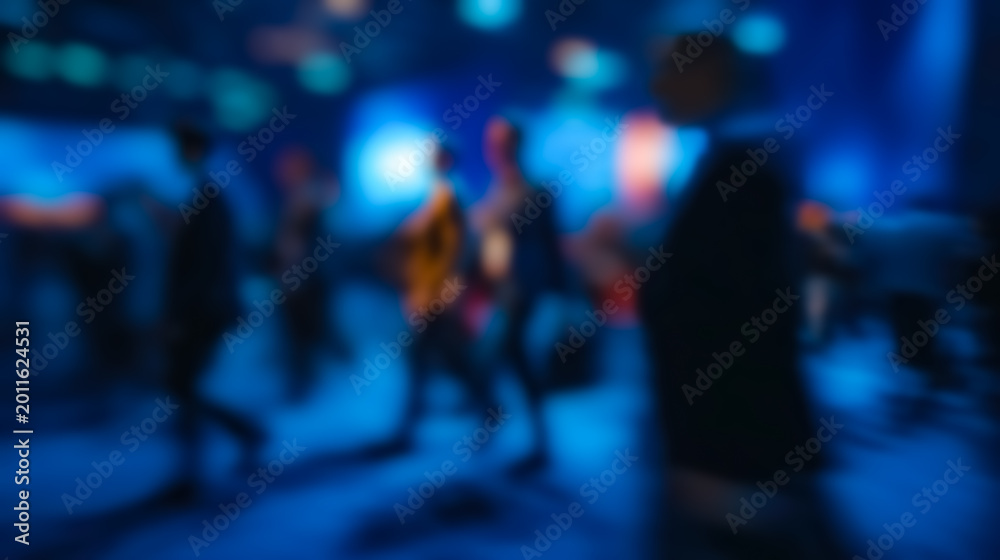 Naklejka premium A sleek office interior with bright lighting and glass partitions features people walking in soft blur for a corporate abstract scene.