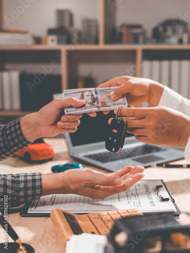 Agreement; buying or selling a new or used car; car keys on the table; warranty or guarantee; customer or salesperson; concept of a car loan or buying a new car.