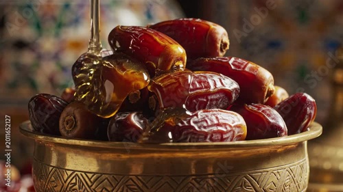 Sweet dates drizzled with golden honey in a decorative bowl, close-up shot, perfect for Ramadan or healthy food concepts