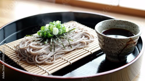 Cold soba noodles served with dipping sauce and chopped green onions, traditional Japanese cuisine, healthy food presentation