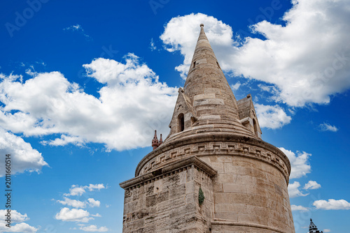 Konstfotografi A stone tower at Fisherman's Bastion in Budapest under a bright blue sky with white clouds