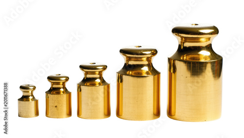 Foto Five polished brass calibration weights of varying sizes, isolated on transparen