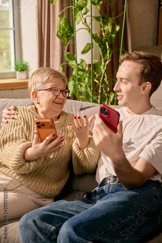 Photography Elderly mother learning online payment from son in sunny living room