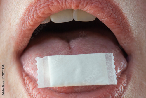 Konstfotografi close up of mouth with white nicotine pouch on tongue concept of sublingual snus