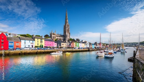 colorful buildings and old boats with cathedral in background in the harbor of cobh county cork ireland