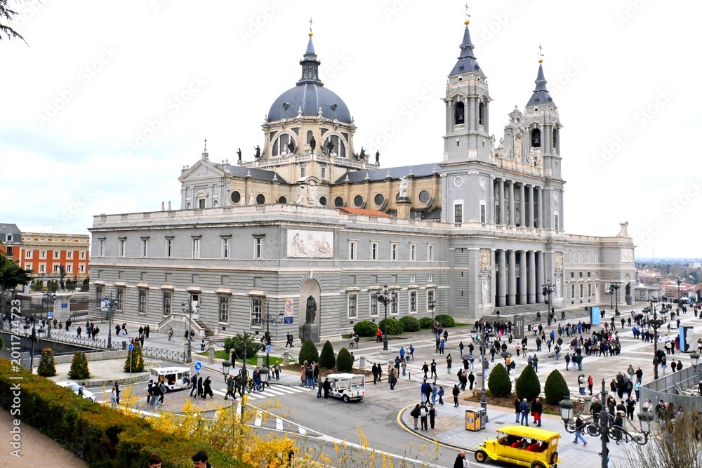 Naklejka premium The impressive Catedral de Santa María la Real de la Almudena rises majestically in the heart of Madrid, surrounded by numerous tourists ,March 15, 2026