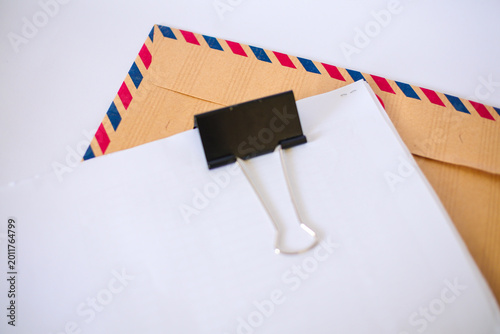 Photography Blank paper with binder clip on airmail envelope isolated on white
