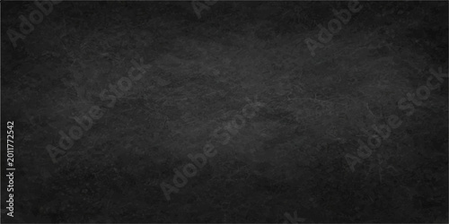 Tableau sur toile A dark and weathered black grunge background features a rough stone wall texture