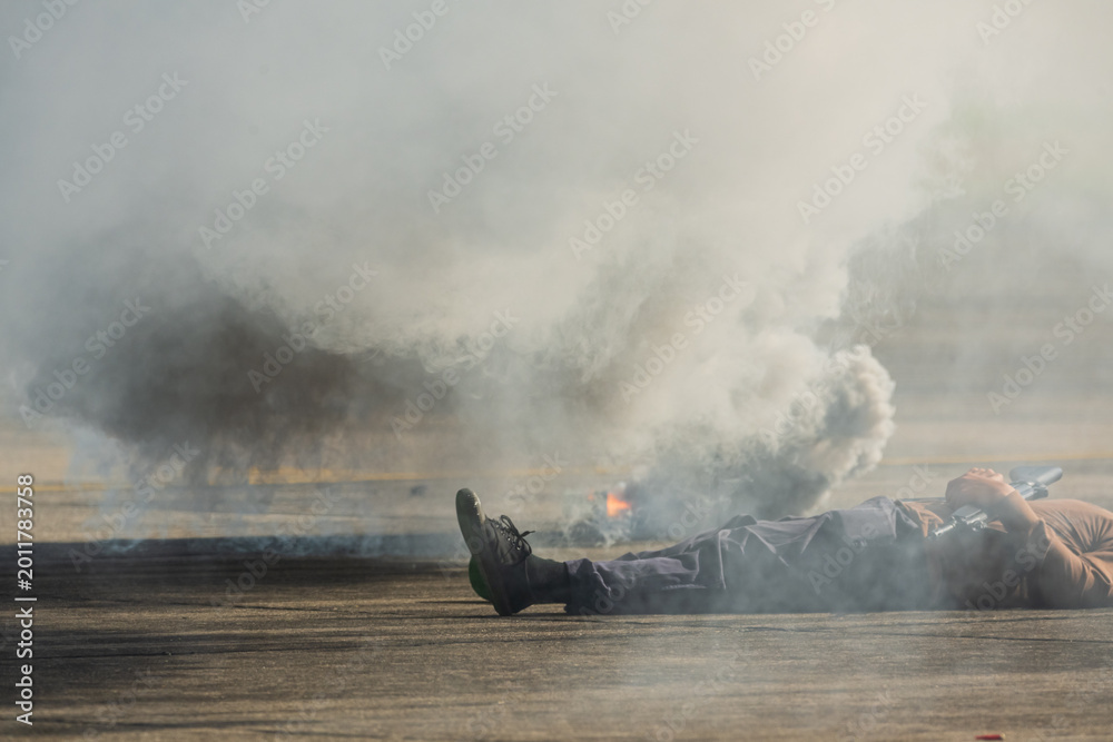 Fototapeta premium Selective smoke from smoke bomb and out of focus terrorist lies dead during military assault drill.The criminal was killed by riot police.A drill simulating a rescue operation against terrorists