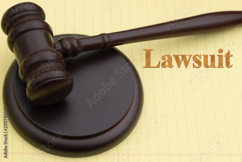 Фотография Lawsuit message with judge gavel and block on legal pad for legal authority