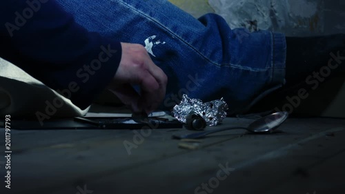 Addict cutting illegal drugs in dark room