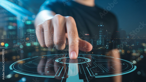 Person Touching Futuristic Digital Interface with Cityscape Overlay at Night technology future