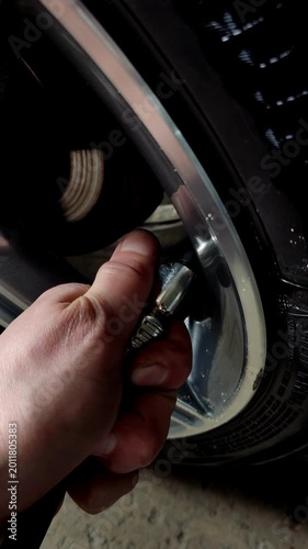 Cinematic close-up of a hand checking tire pressure on car 