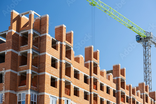 Photos Brick apartment building under construction with tower crane