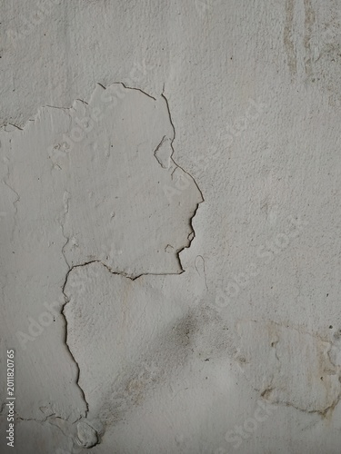 Cracked white plaster wall texture with rough surface and peeling details, abstract grunge background with aged concrete pattern and minimalist urban style.