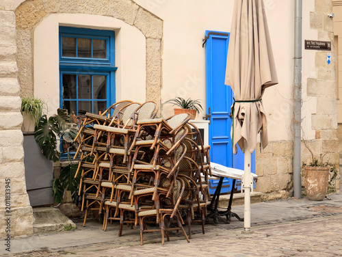 Tableau sur toile A pile of chairs from an outdoor café, waiting for the season to open