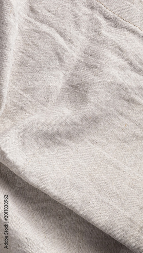 Wrinkled natural linen fabric texture background with soft creases and folds. Abstract textile backdrop