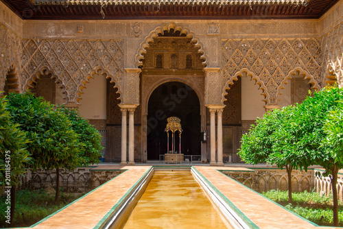 Foto Ornate Courtyard Oasis: An evocative photograph captures the architectural grandeur of a sun-drenched courtyard, with intricate patterns, graceful arches, and the serenity of a reflecting pool