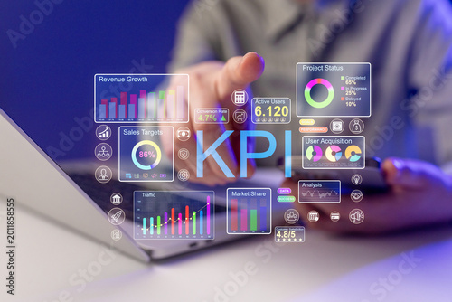 Business professional reviews key performance indicators and data on a laptop in an office setting at night