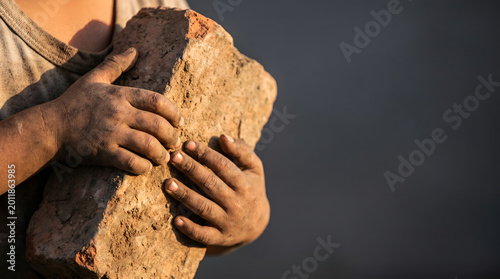 World Day Against Child Labour banner with child hands holding heavy brick and copy space