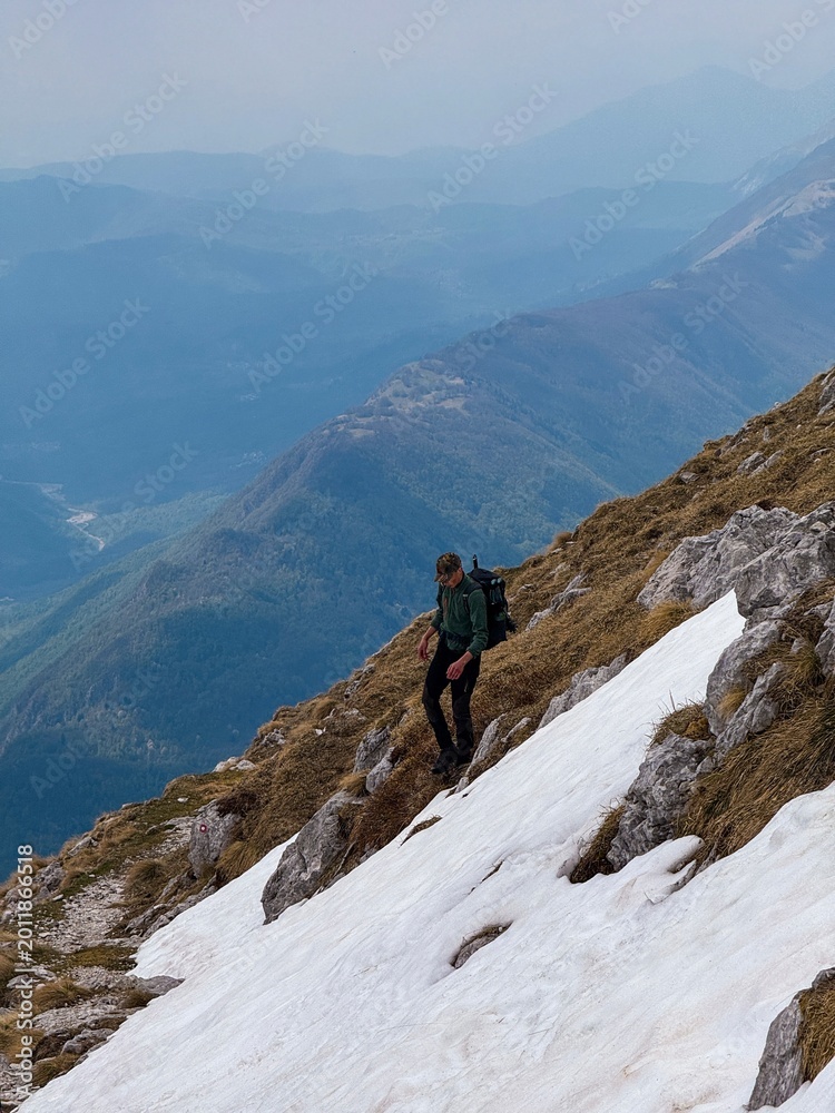 Fototapeta premium Trekking Through Spring Mountains with Snow