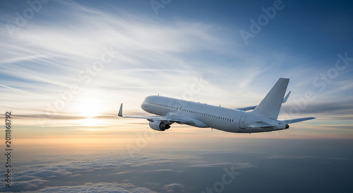 White passenger jet airplane flying above clouds at sunset with sun rays