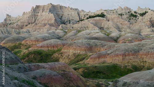 Photos Pale mountains rise above painted mounds in the Badlands