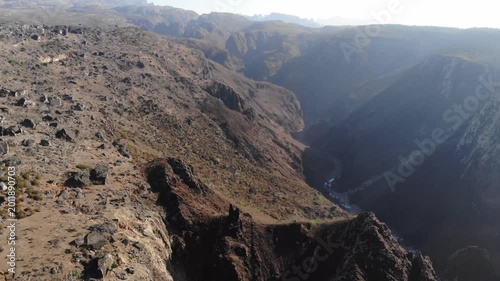 Aerial video flight over a deep rocky canyon and dry mountain valley on socotra island yemen, perfect for rugged nature travel documentaries, exotic wilderness exploration or desert backgrounds
