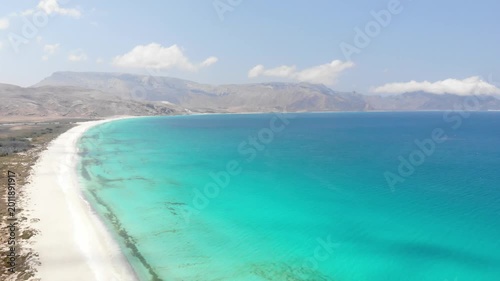 Panoramic aerial video of Socotra Island's rugged coastline, where desert cliffs meet the turquoise ocean, perfect for travel and adventure footage