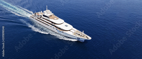 Aerial drone ultra wide panoramic photo with copy space of luxury yacht with wooden deck cruising near port Port Hercules in deep blue sea, Monaco, France